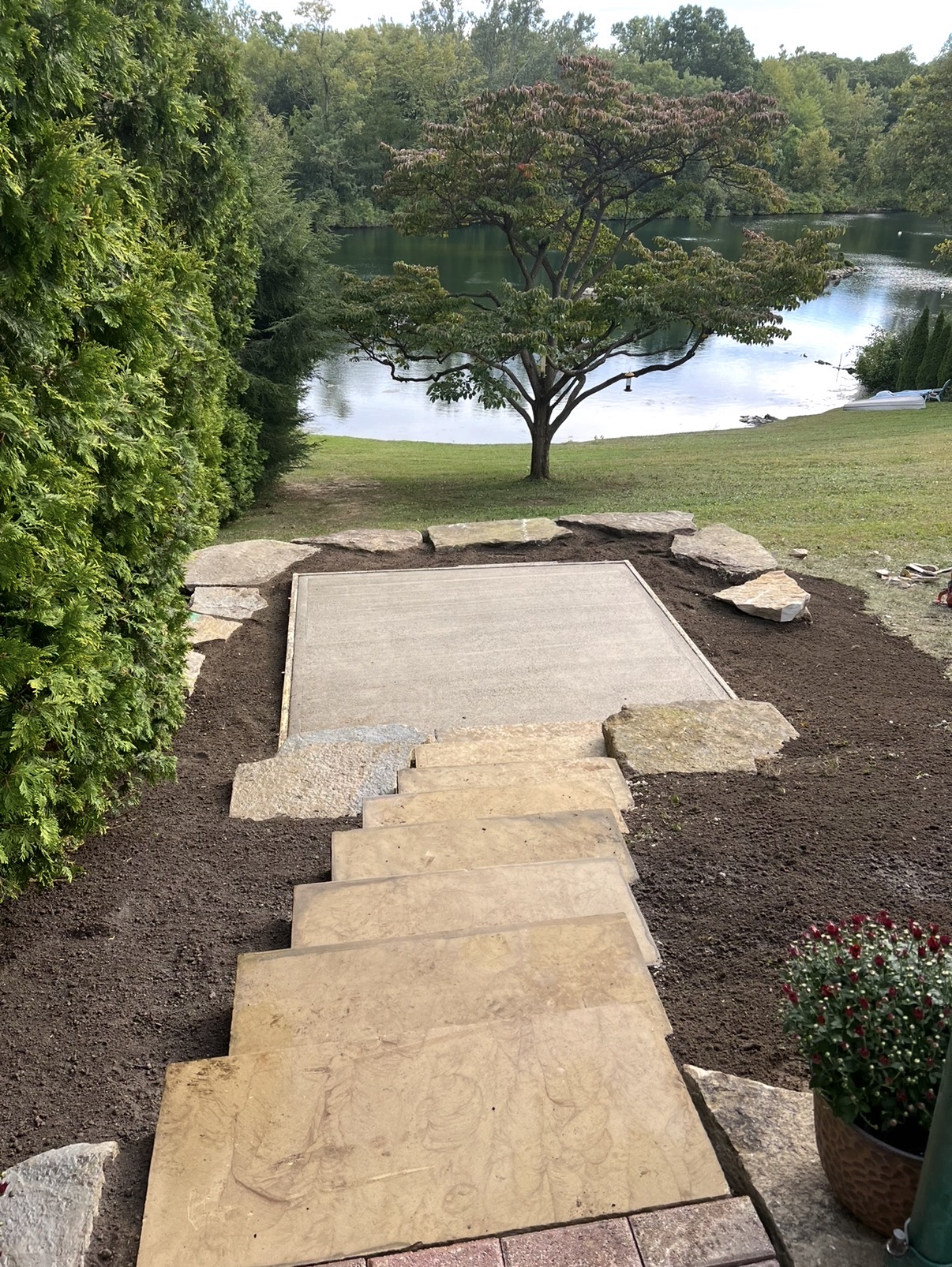 Oversized stone slabs stepped down a slope to a new landing overlooking the lake.